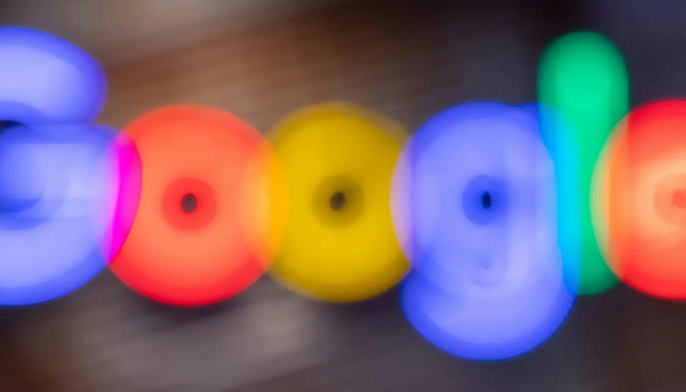 Logo de Google desenfocado con luces de colores, representando datos y paneles de análisis